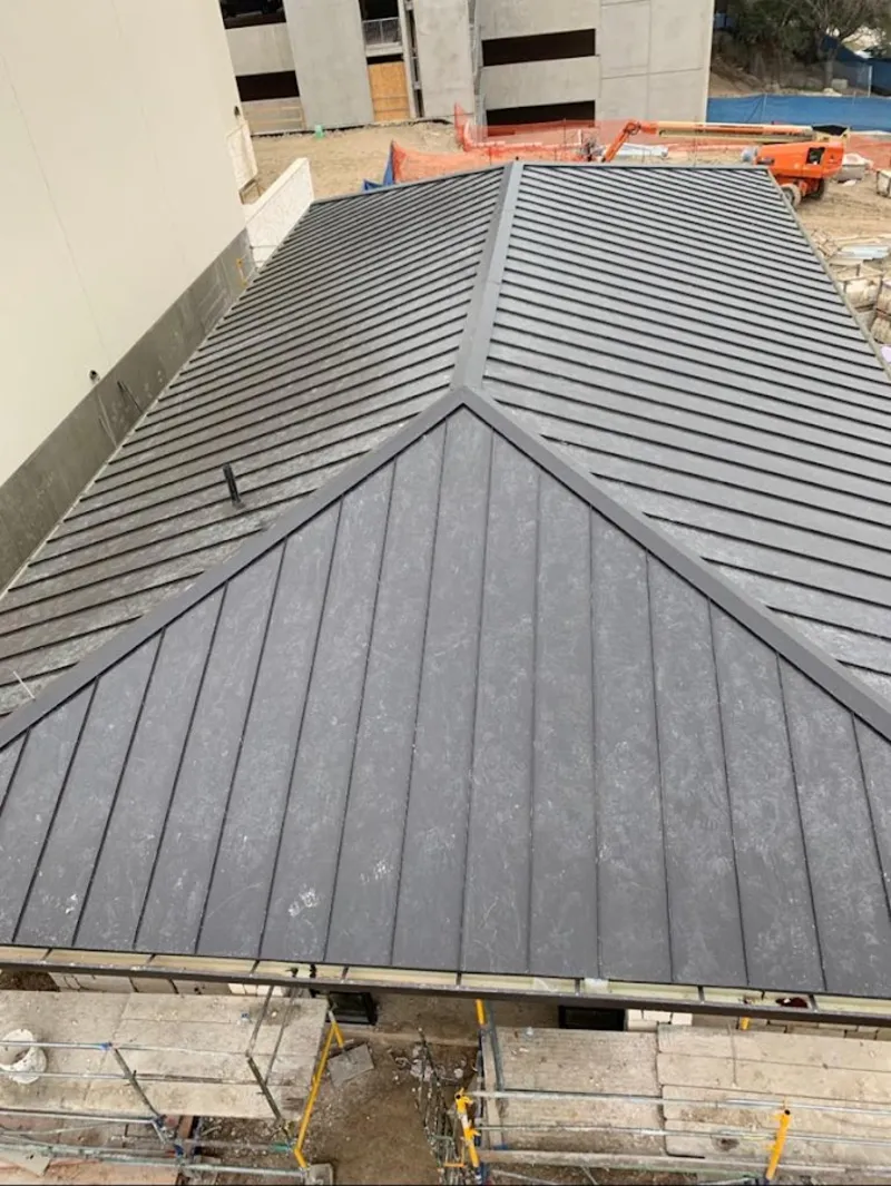 Commercial metal roof construction with crane equipment in Bartlesville