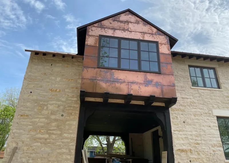 Copper metal panel facade on a stone building for Roof Repair in Bartlesville